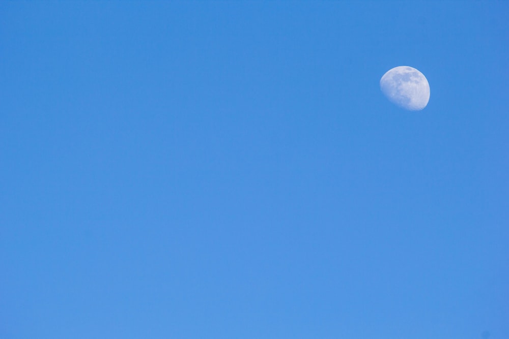 a plane flying in the sky with the moon in the background