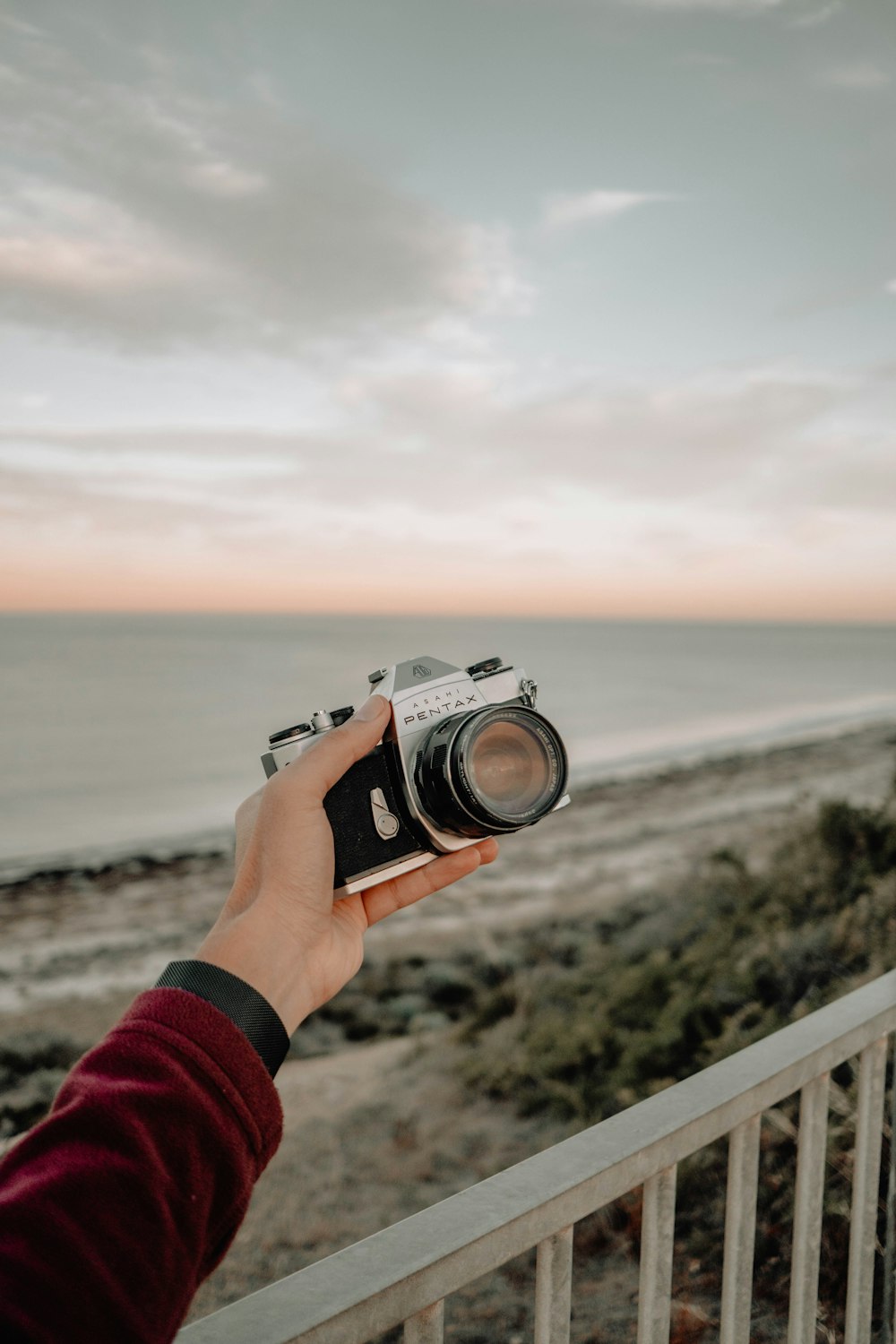 a person taking a picture of a beach with a camera