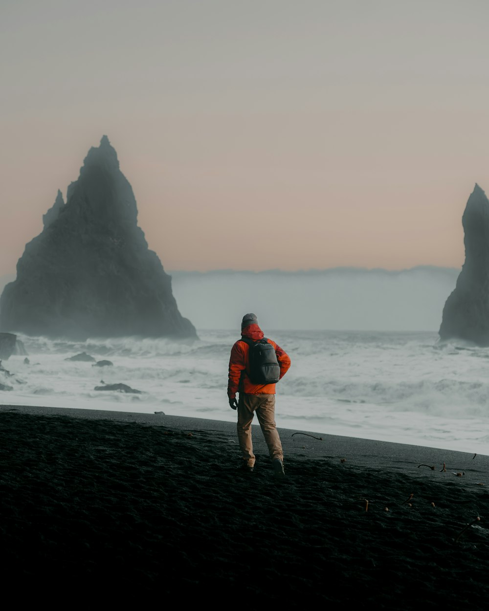 eine Person, die an einem Strand in der Nähe des Ozeans spazieren geht