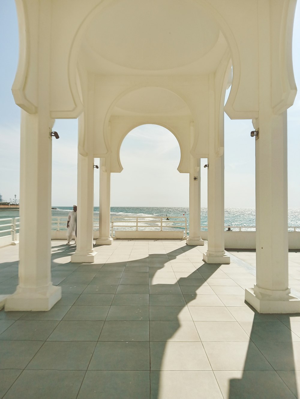 a row of white pillars sitting next to the ocean