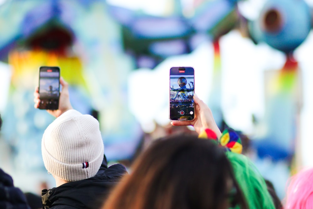 a group of people taking pictures with their cell phones