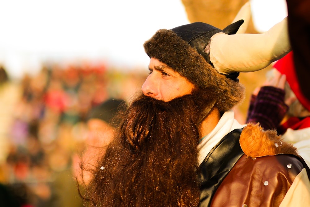 a man with long hair and a beard wearing a horned hat