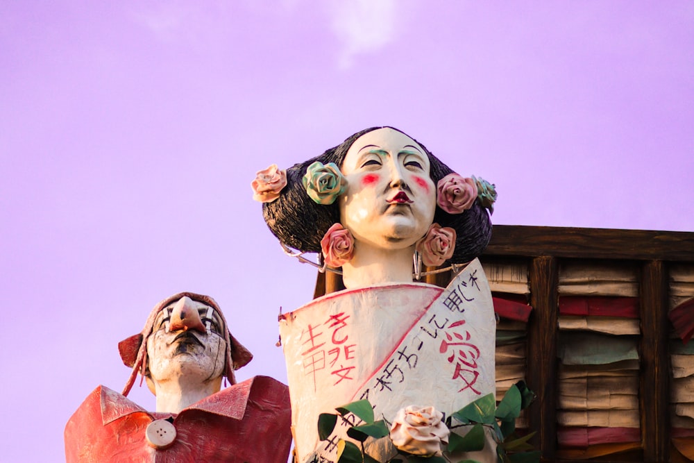 a statue of a woman holding a bucket next to a statue of a man