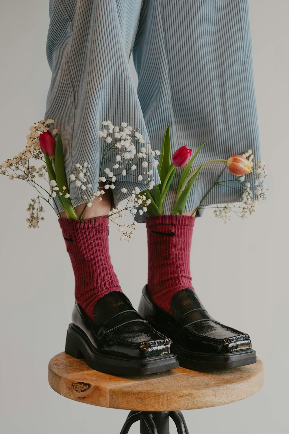 a pair of legs with socks and flowers on a stool