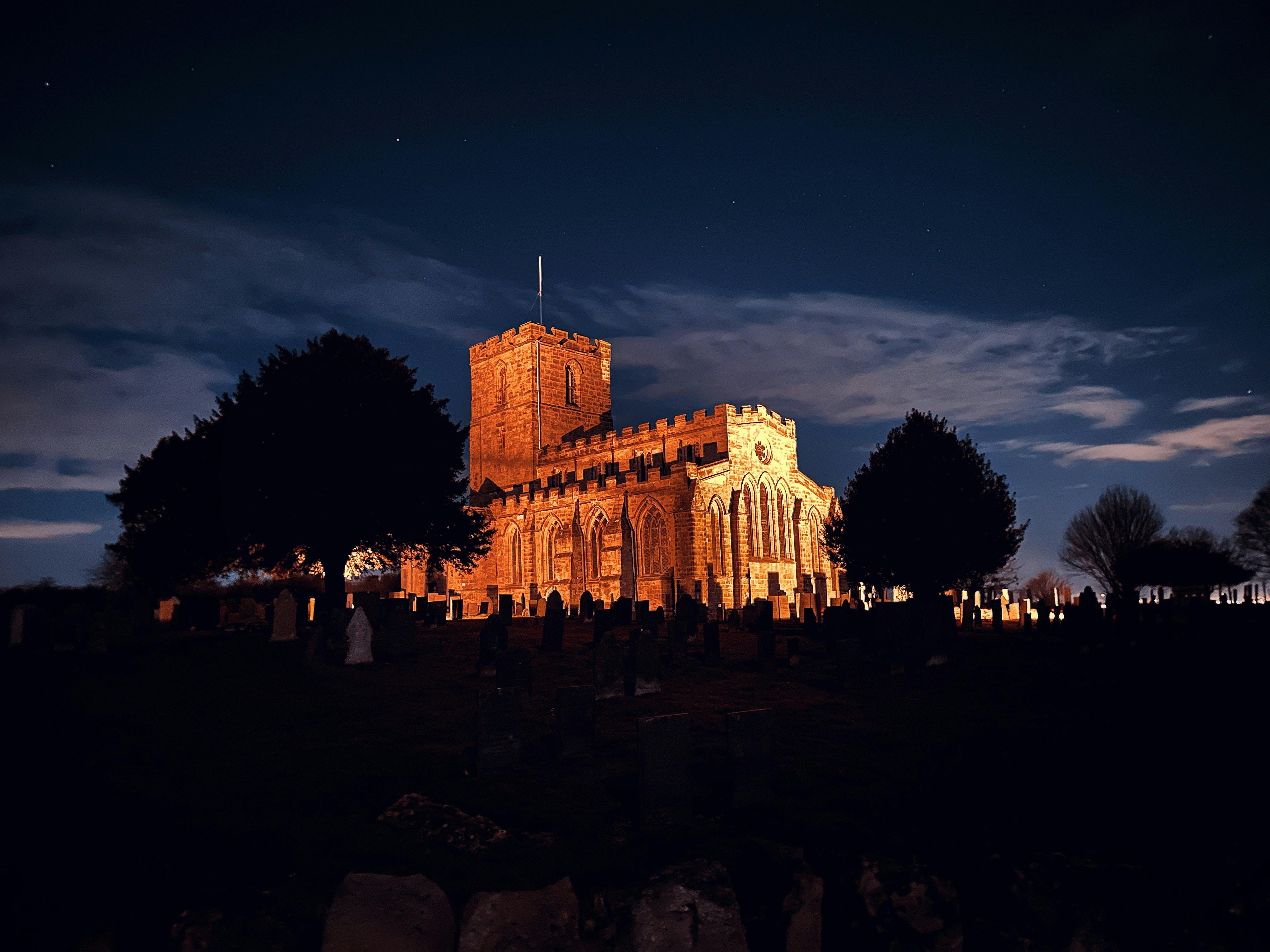 a church lit up at night with a sky background