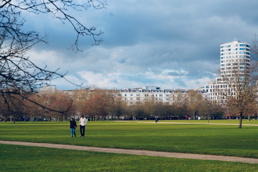 a couple of people that are standing in the grass