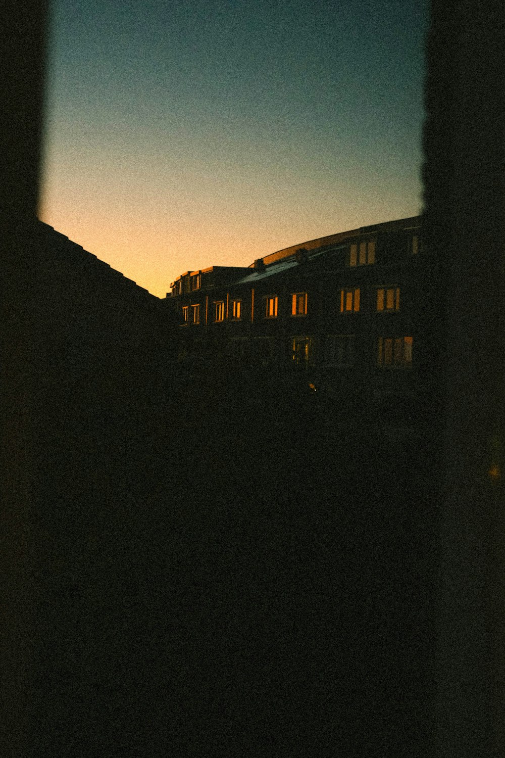 uma vista de um edifício de uma janela à noite
