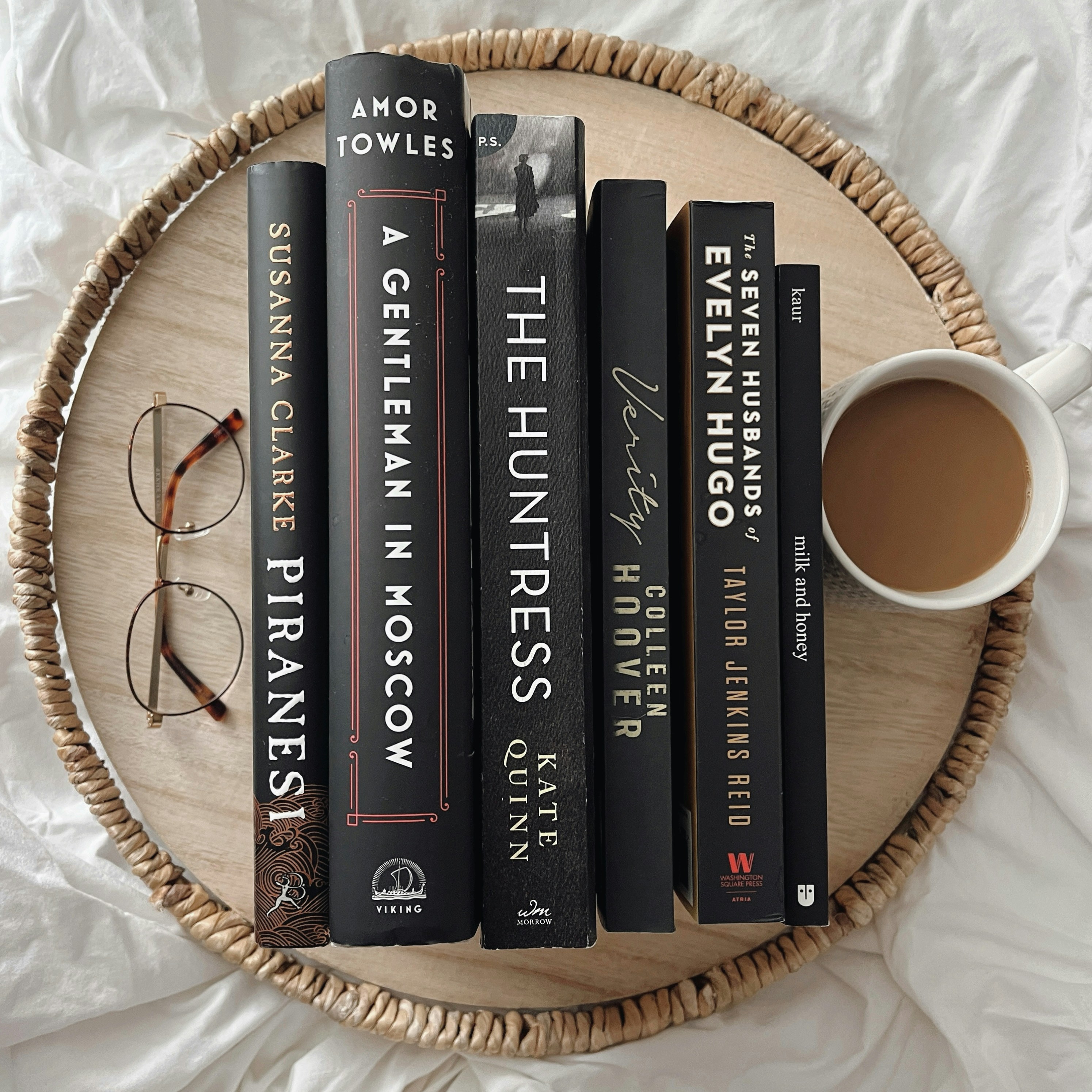 a wicker basket holding a few books and a cup of coffee