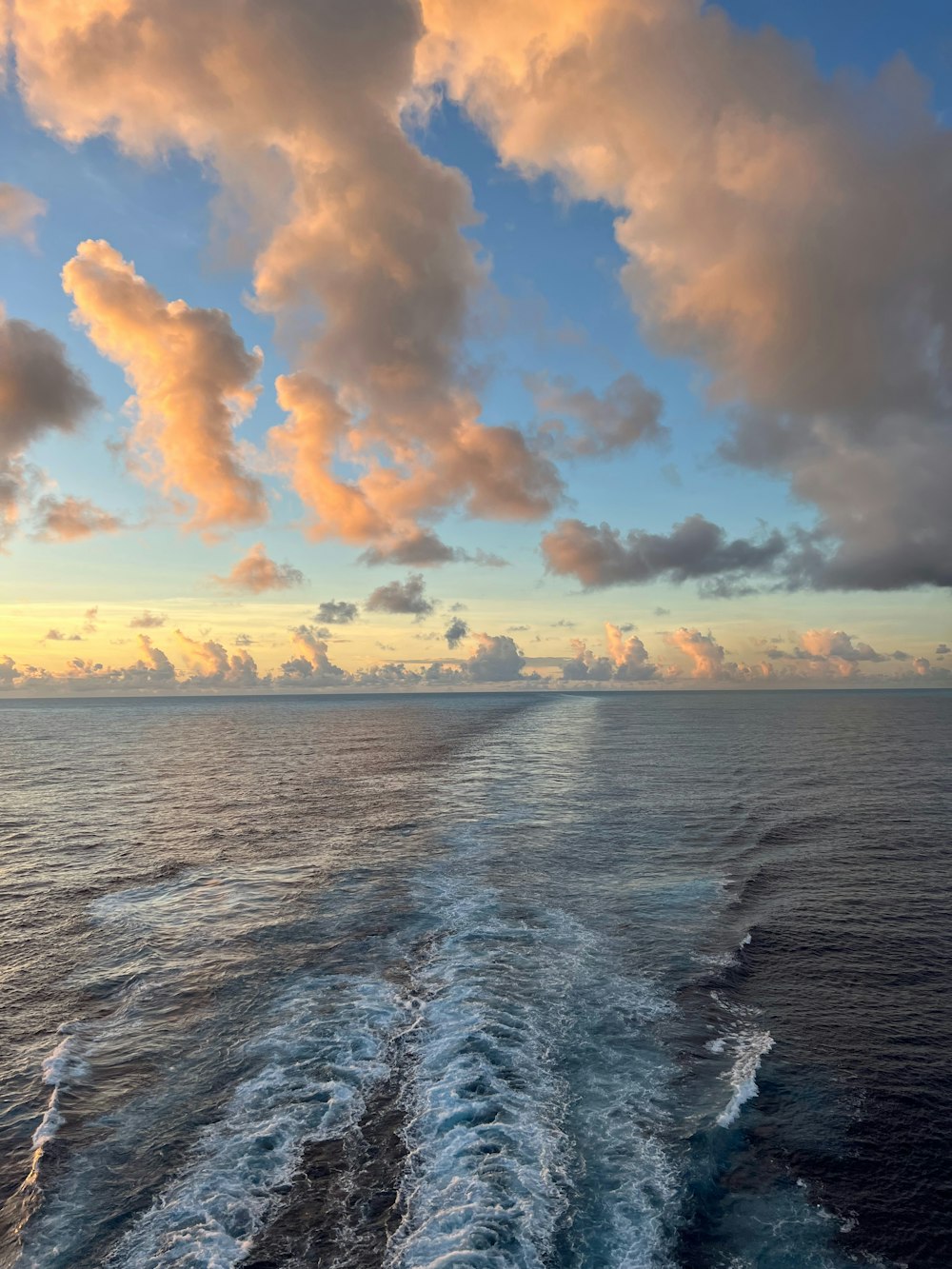 la scia di una barca nell'oceano al tramonto