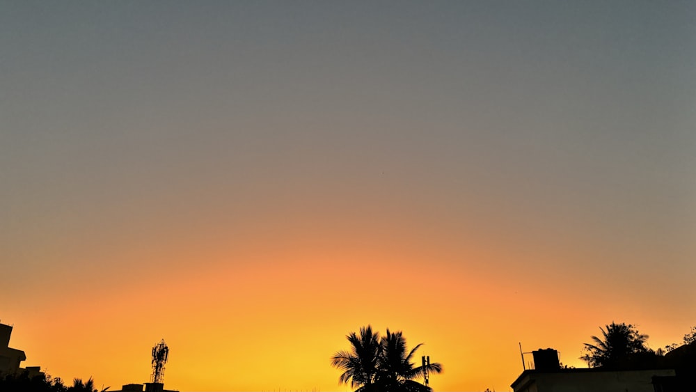 the sun is setting over a city with palm trees