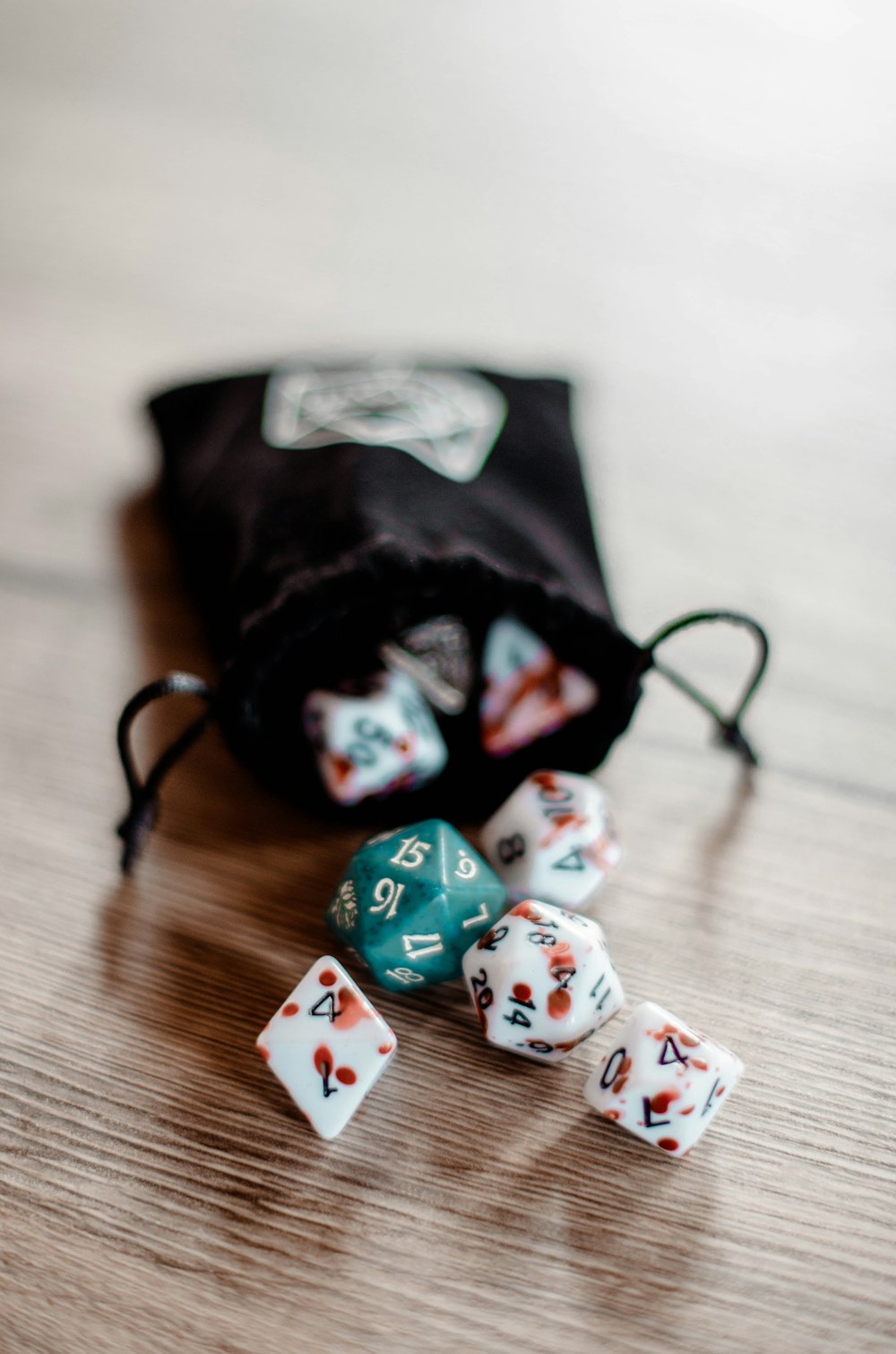 a bag filled with dice sitting on top of a wooden table
