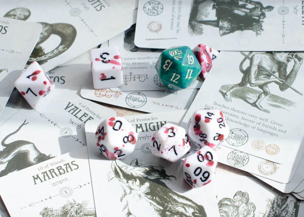 a pile of dice sitting on top of a pile of cards