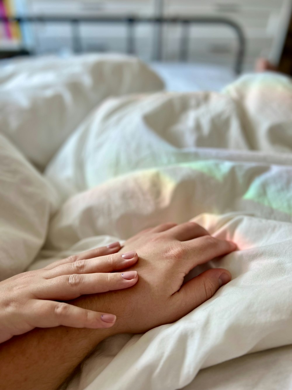 a person laying in a bed with white sheets