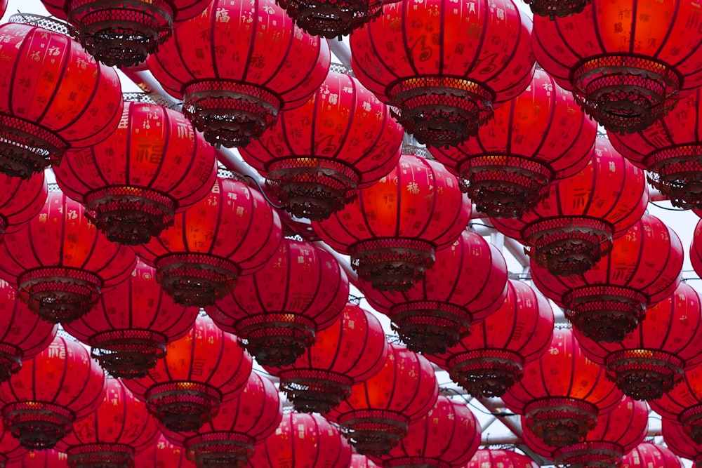 a bunch of red lanterns hanging from a ceiling