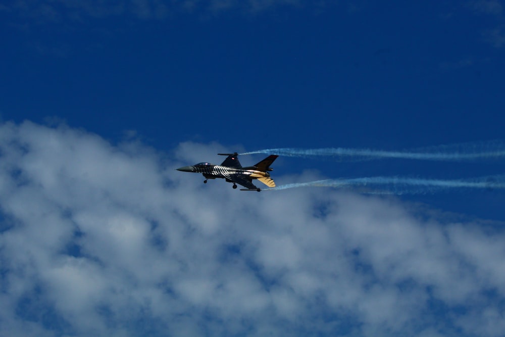 a plane flying in the sky with smoke coming out of it