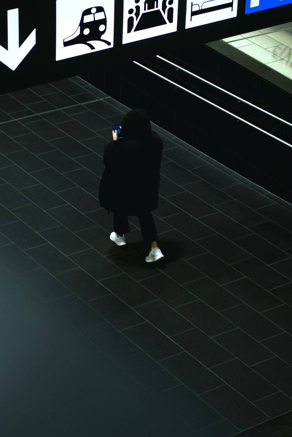 a person in a black coat and white shoes