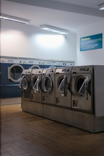 a row of washers in a public laundment