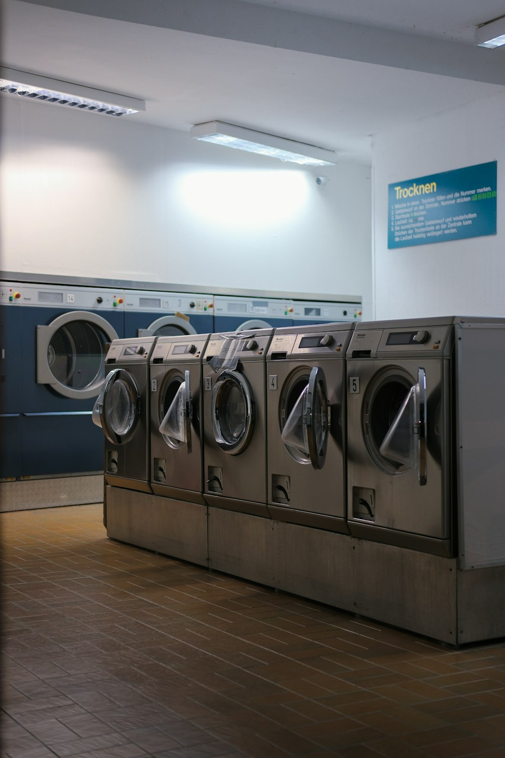 a row of washers in a public laundment