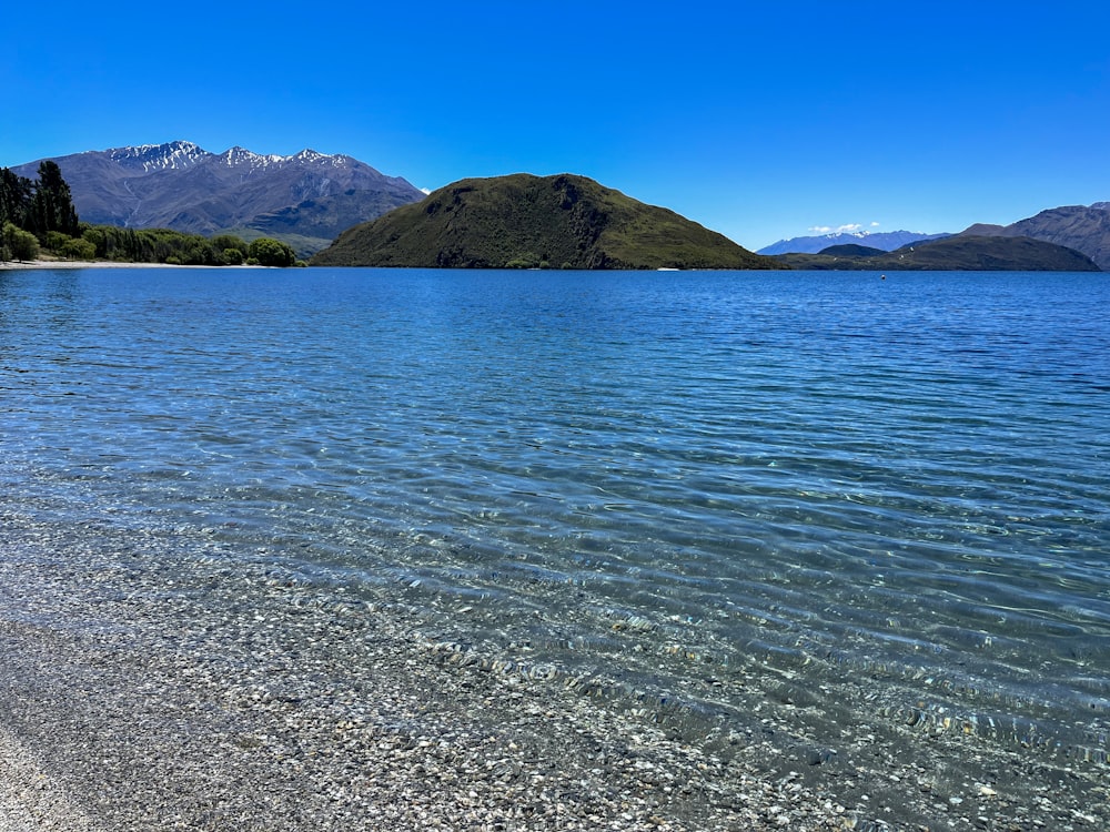 a body of water with mountains in the background