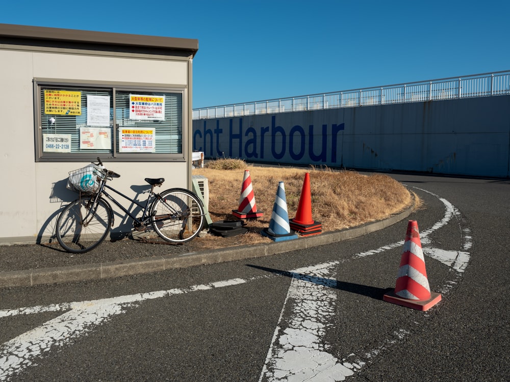 a bike parked next to a traffic cone on the side of a road