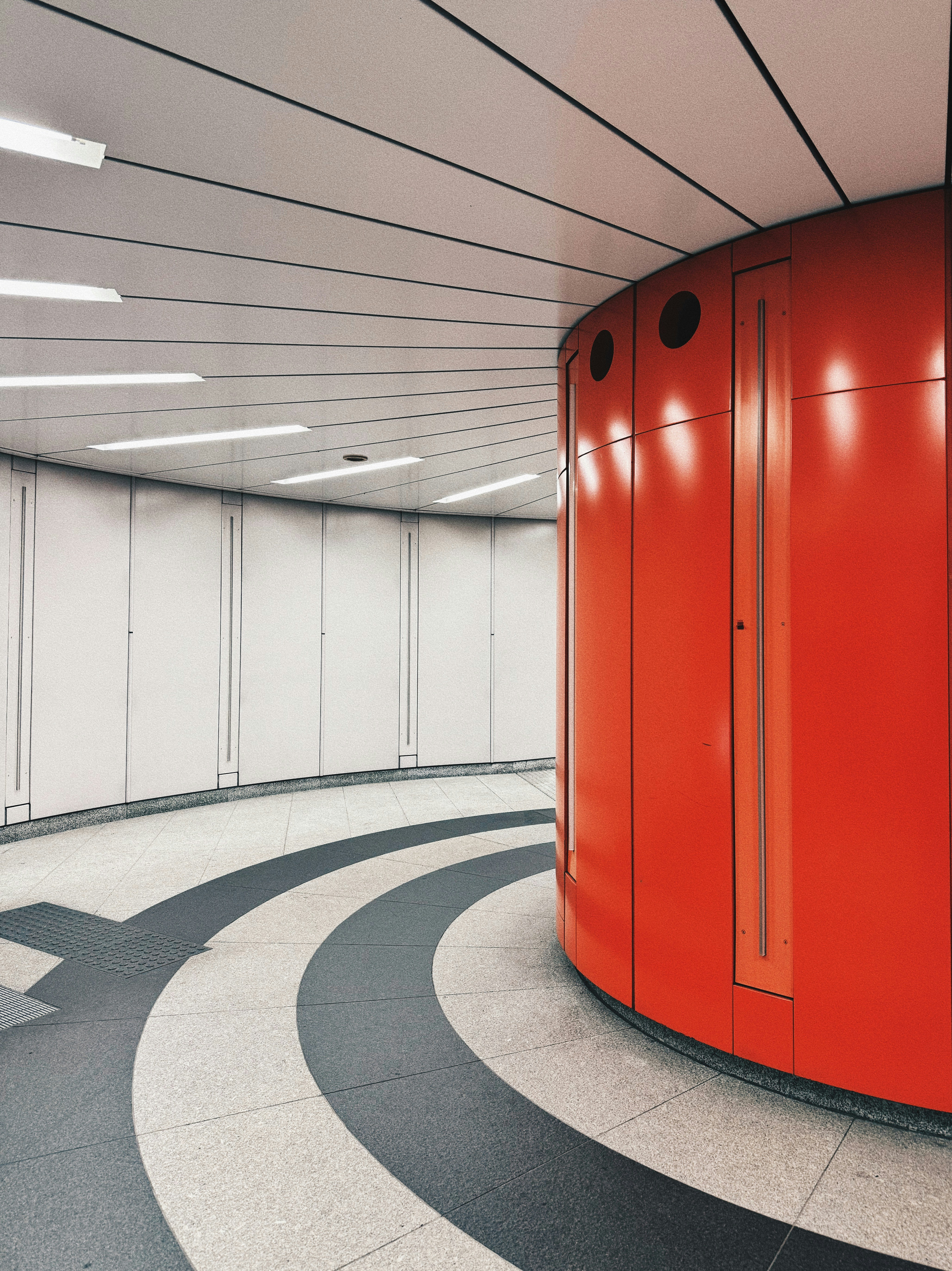 Ein runder Raum mit roter Wand und schwarz-weißem Boden