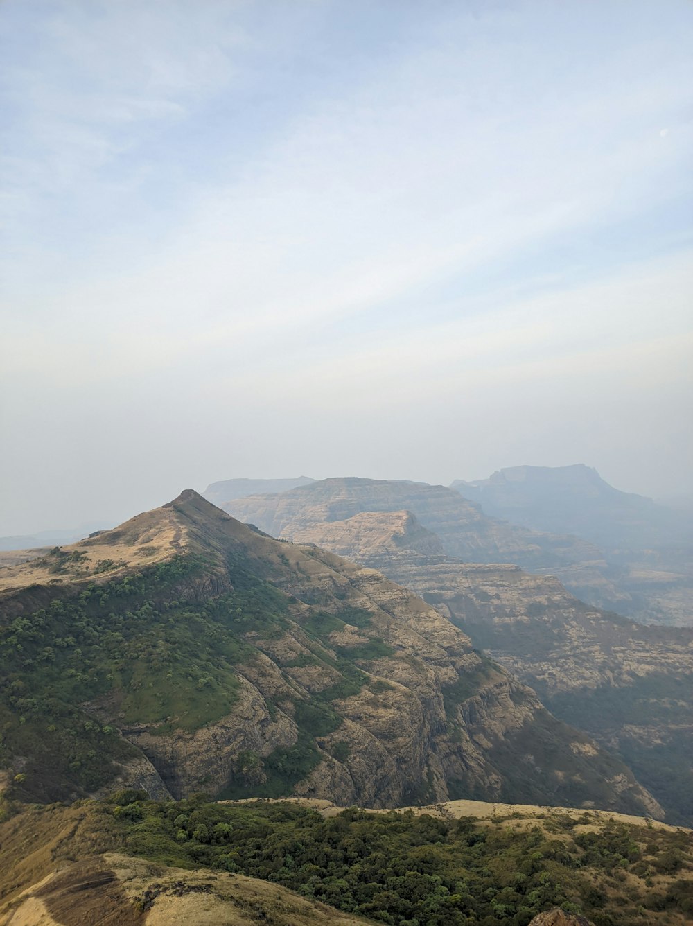 a view of a mountain range from the top of a hill