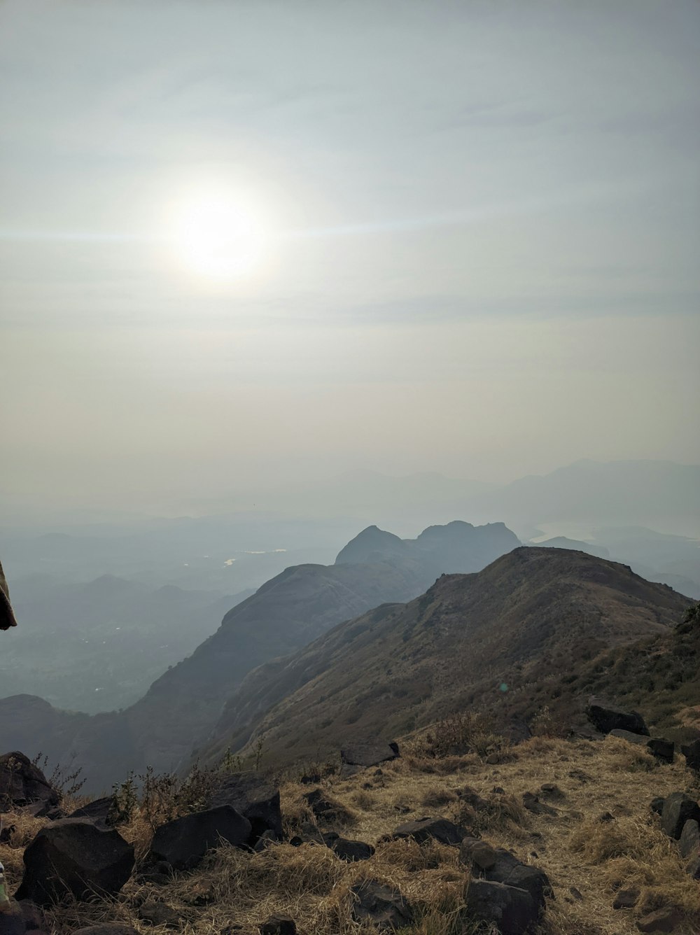 a person sitting on a rock looking at the mountains