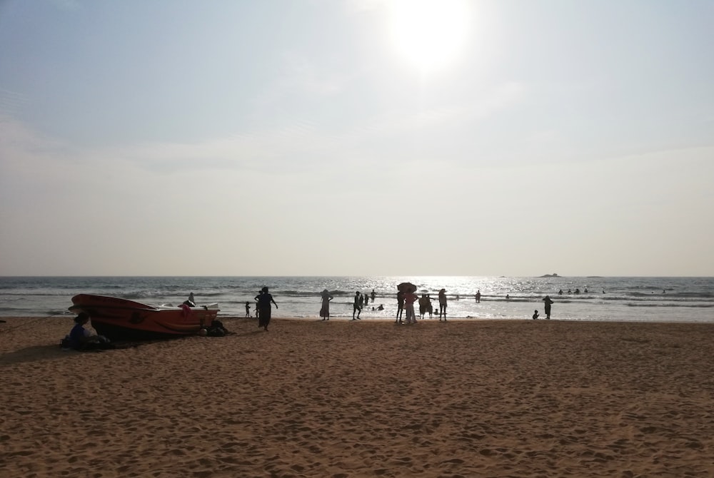 a group of people standing on top of a sandy beach