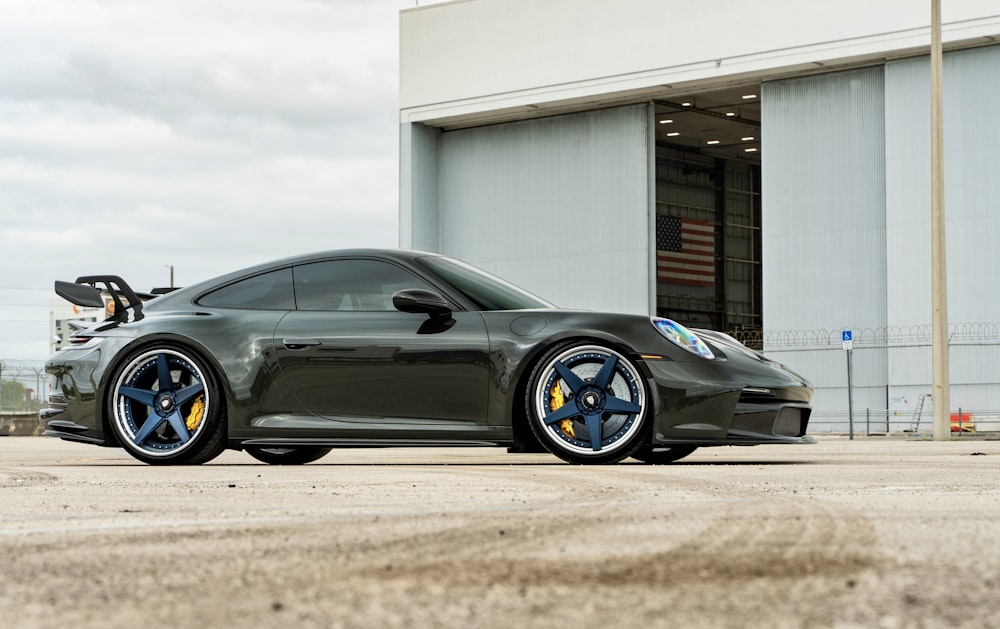 a green sports car parked in front of a building