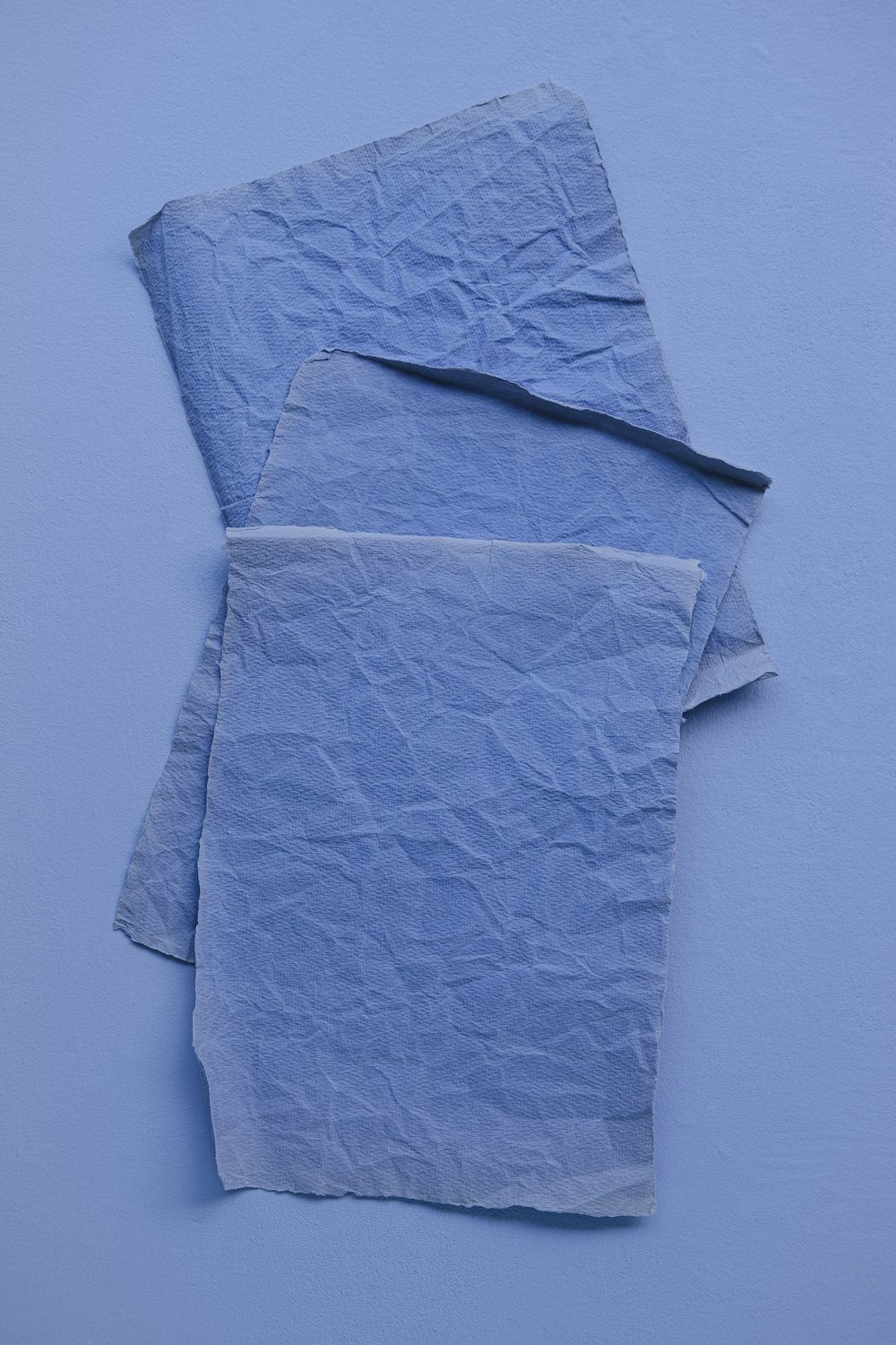 two pieces of blue paper on a blue surface
