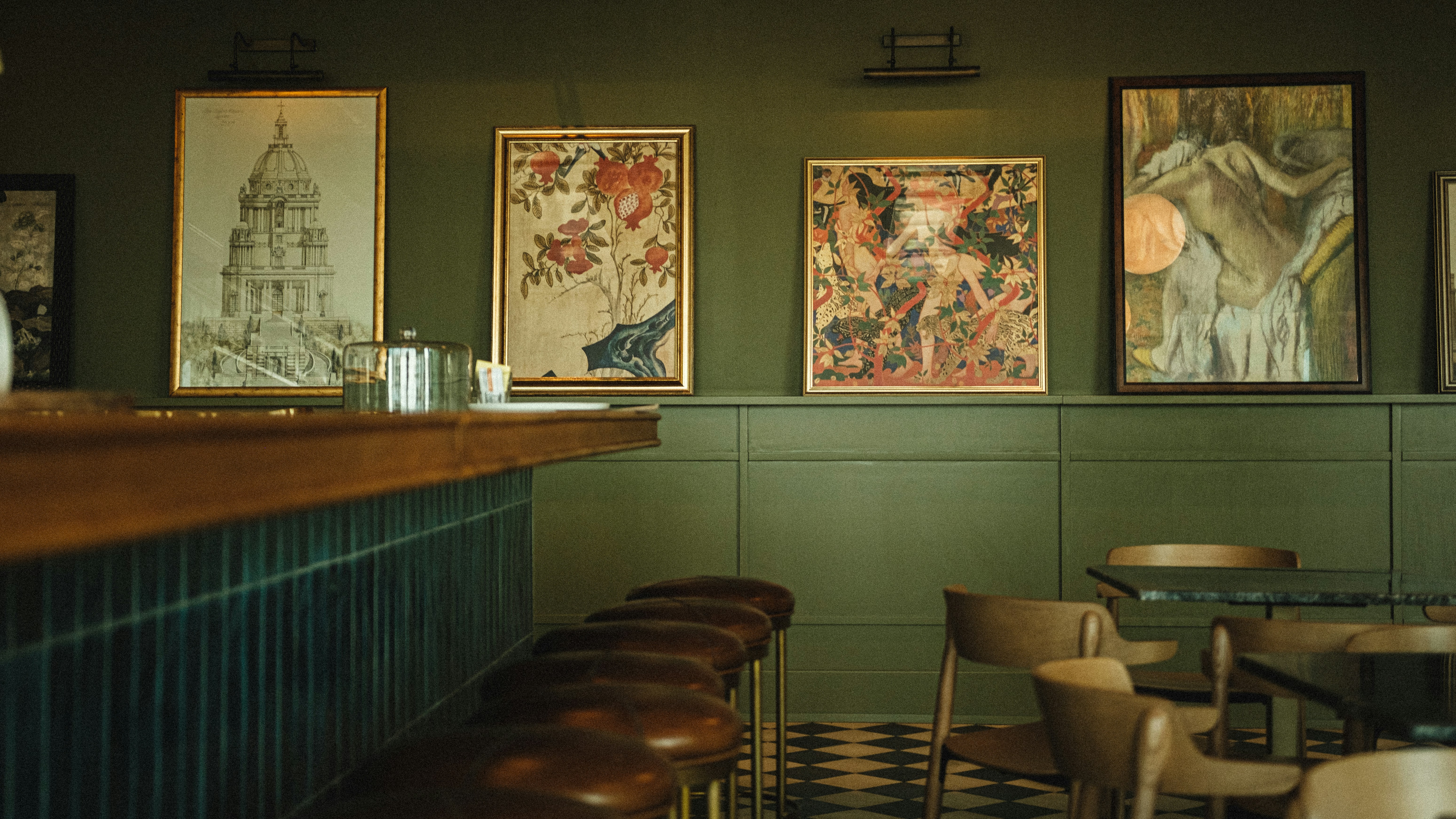 a restaurant with green walls and pictures on the wall