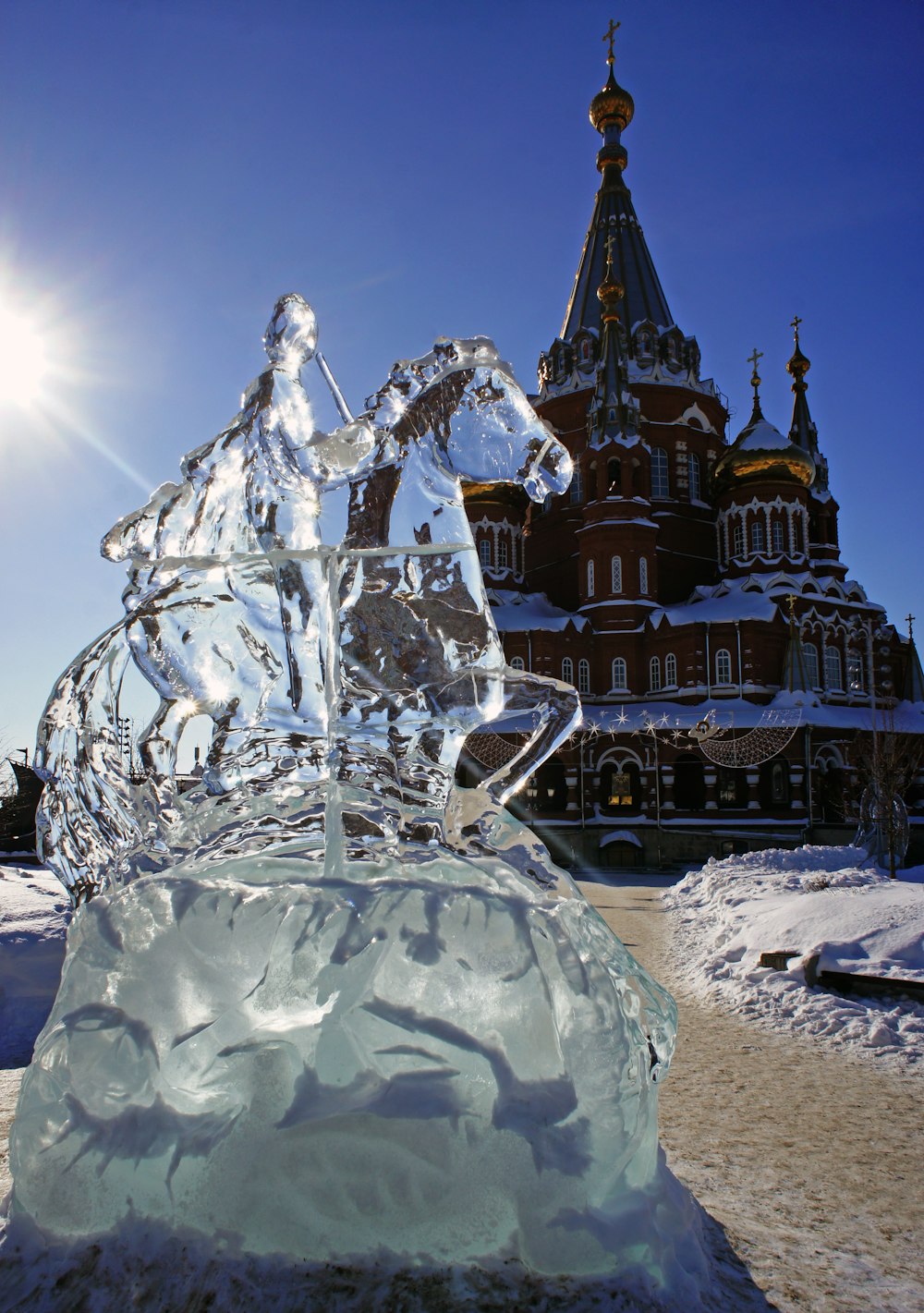 an ice sculpture of a horse and rider in front of a building