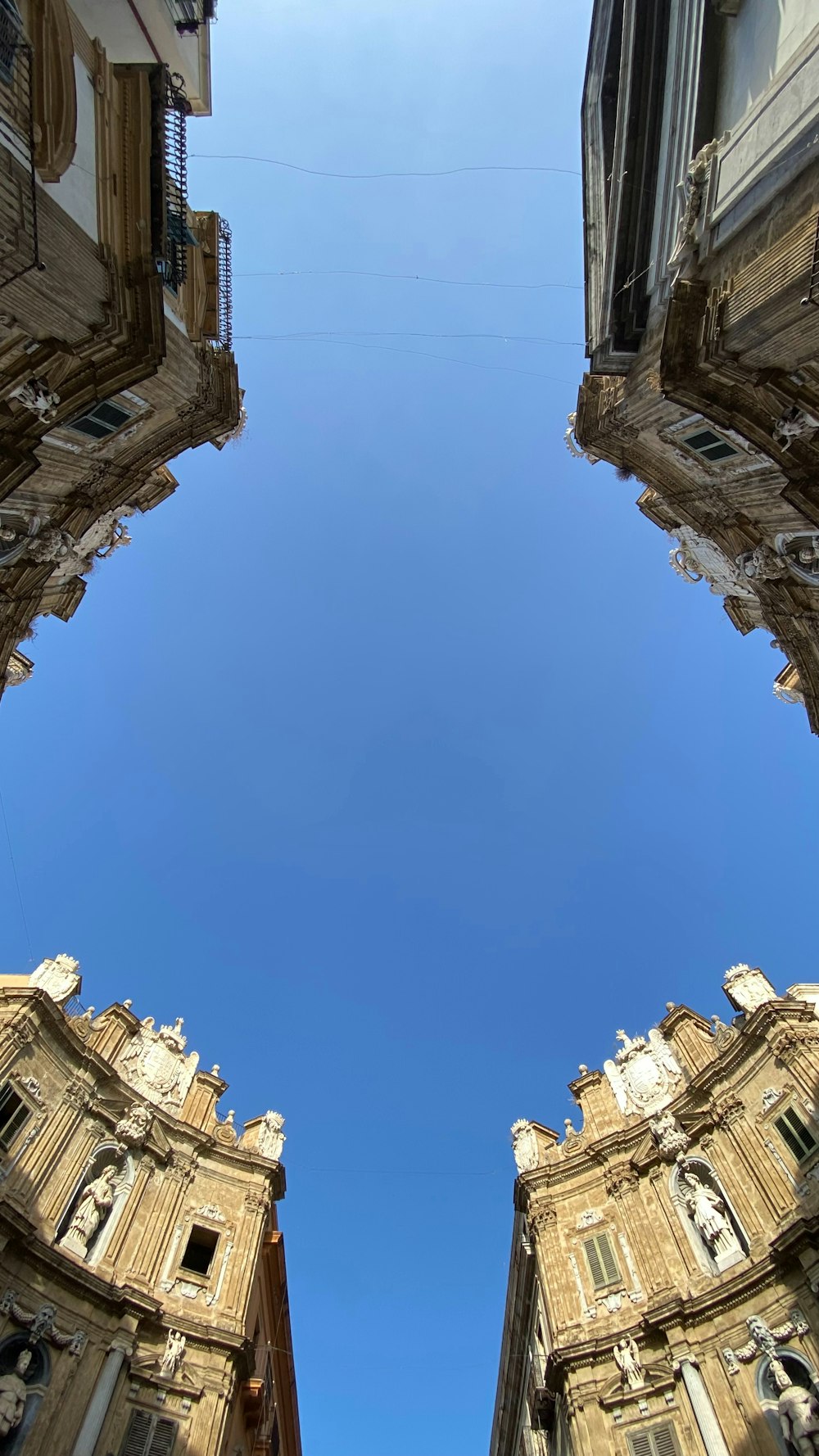 Alzando lo sguardo verso un alto edificio con un cielo azzurro sullo sfondo