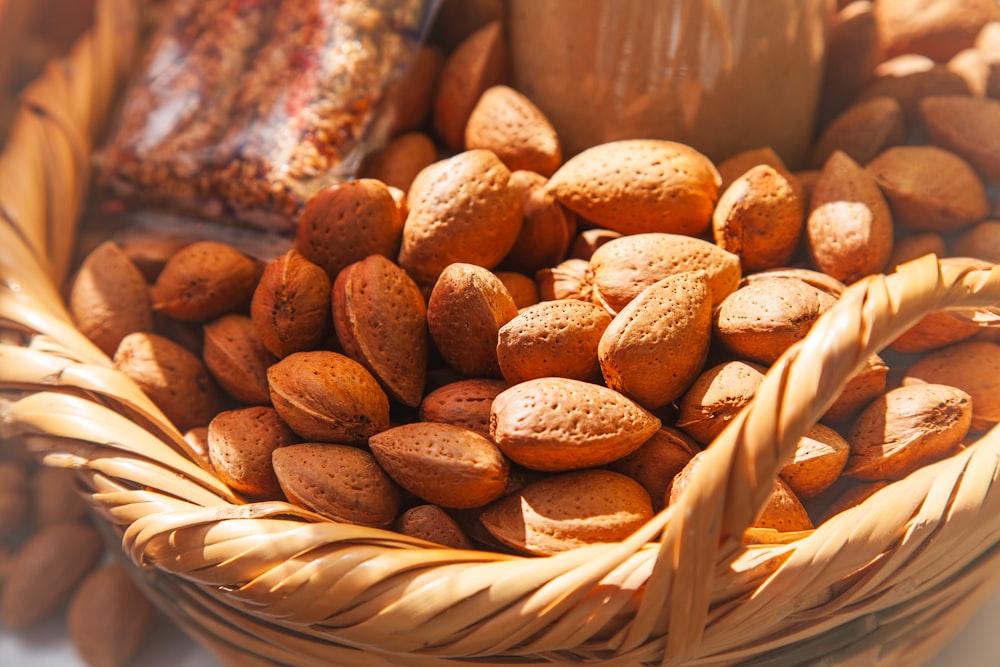 a basket filled with nuts next to a jar of peanut butter