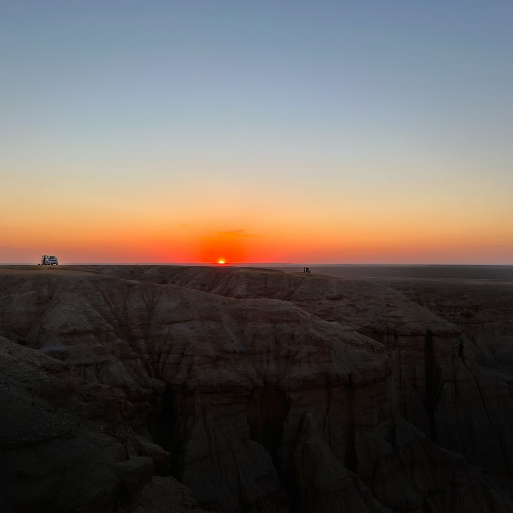 the sun is setting in the distance over the desert