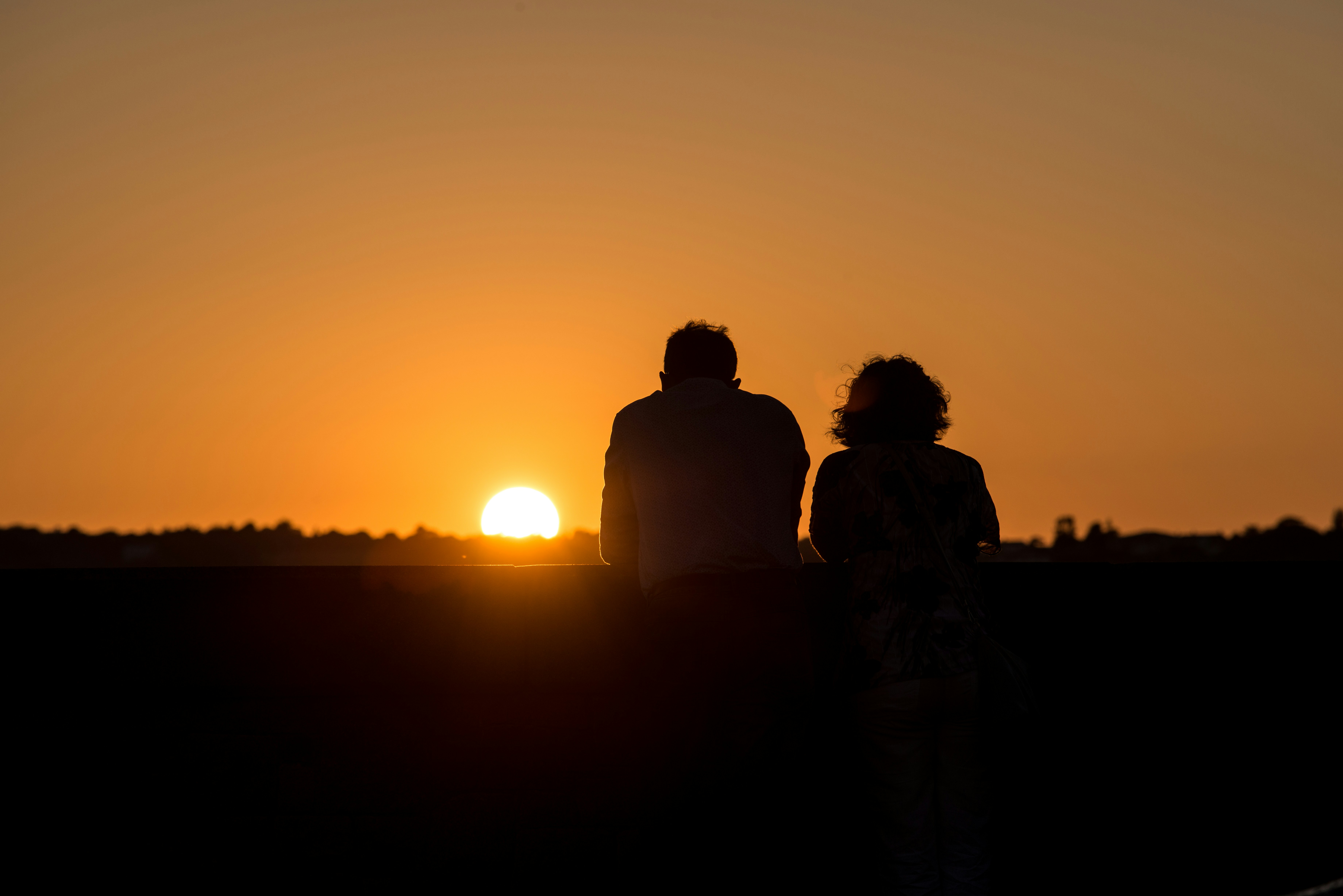 Couple watching an orange sunset