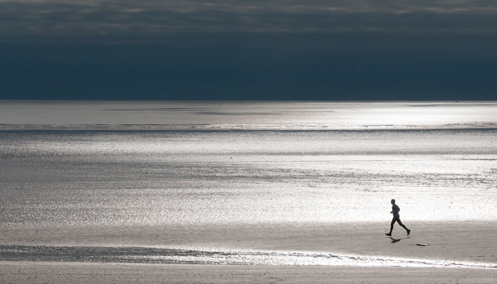 a person walking on a beach near the ocean