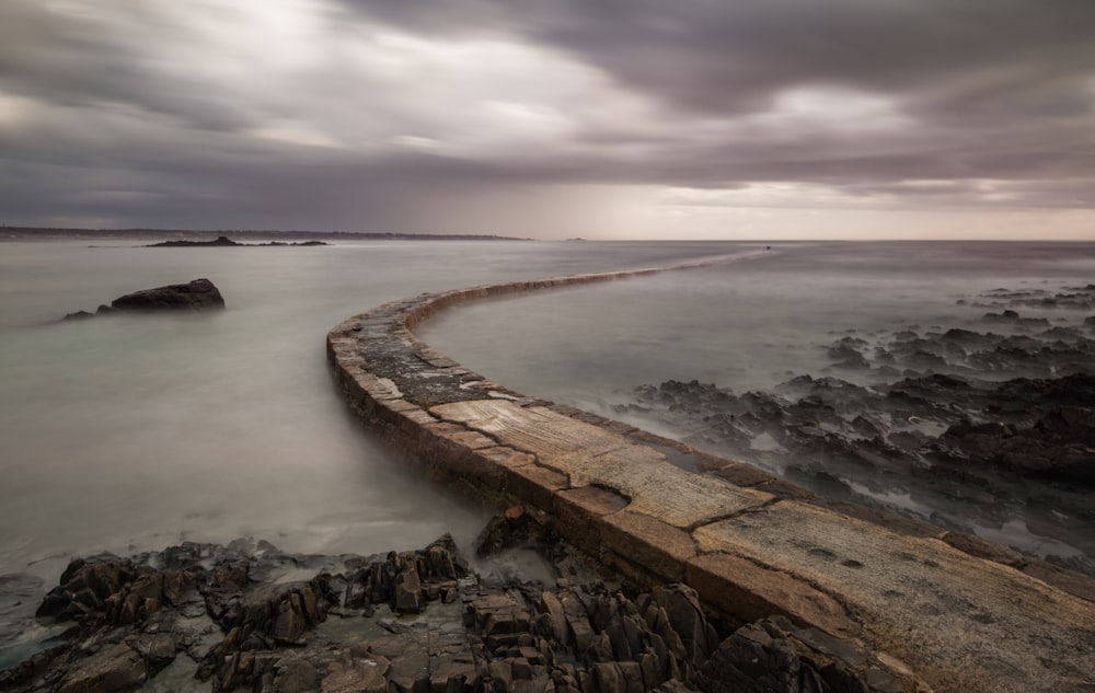 a long exposure photo of the ocean and rocks