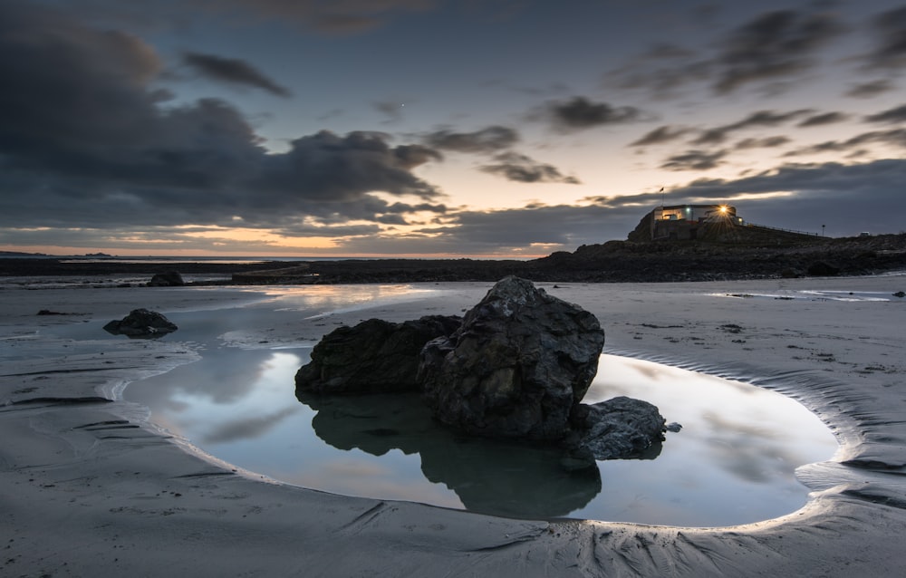 a large rock sitting on top of a sandy beach