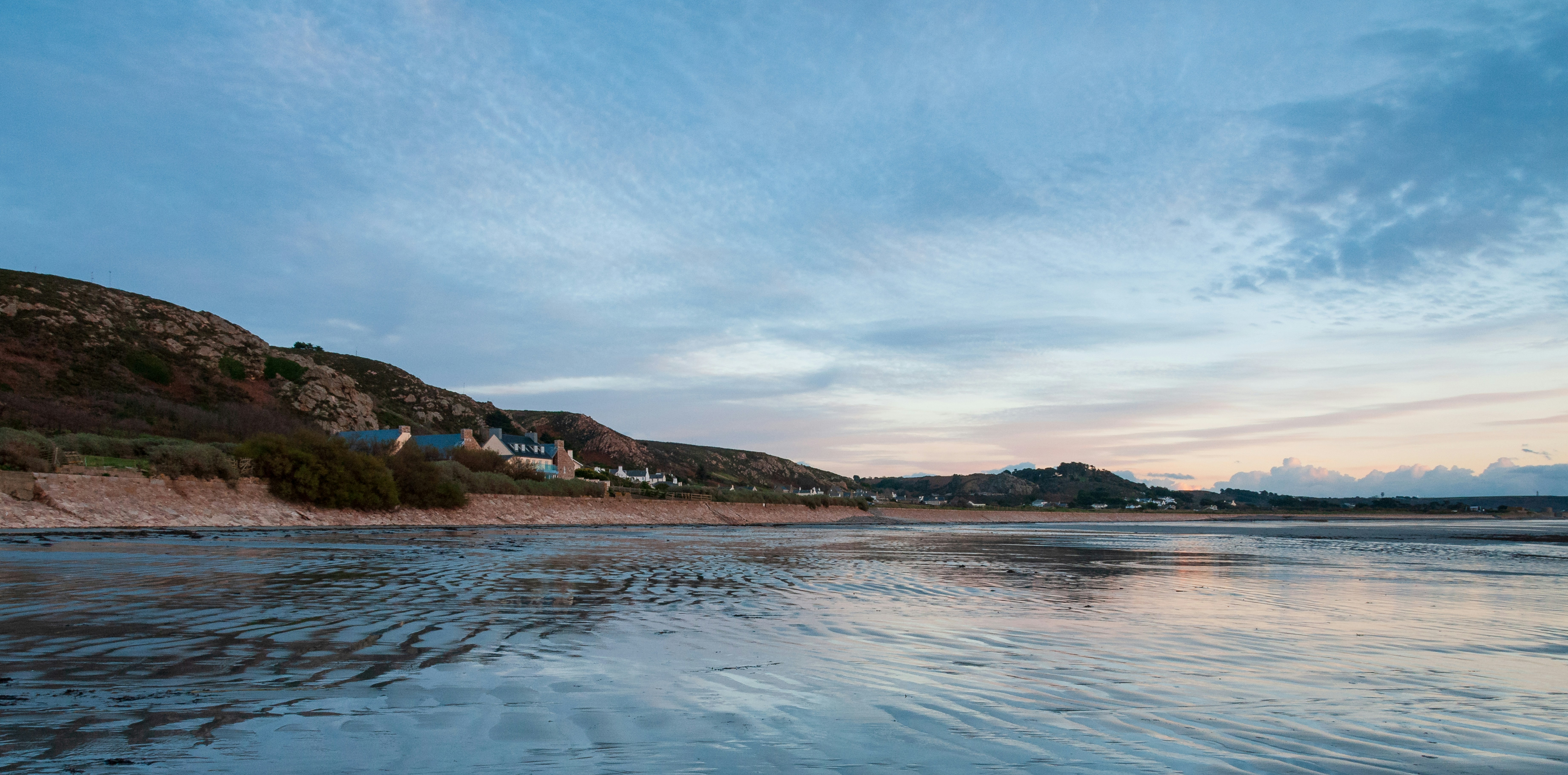a view of a beach with a hill in the background