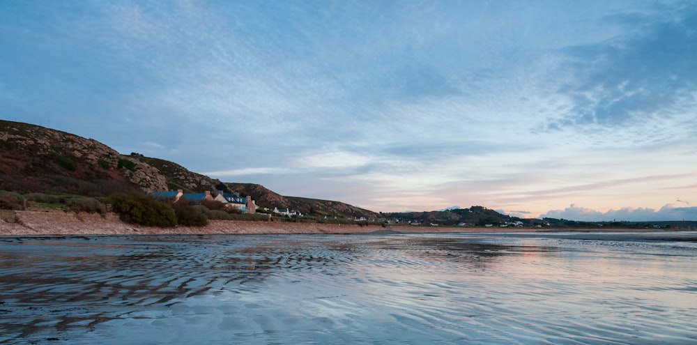 a view of a beach with a hill in the background