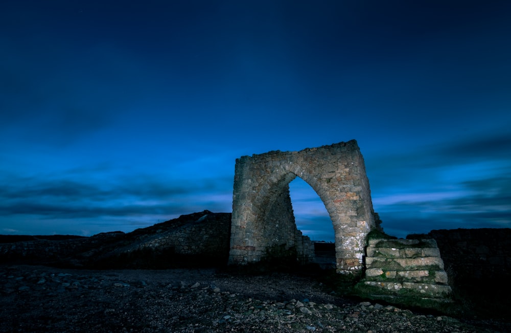 a stone arch sitting on top of a rocky hillside