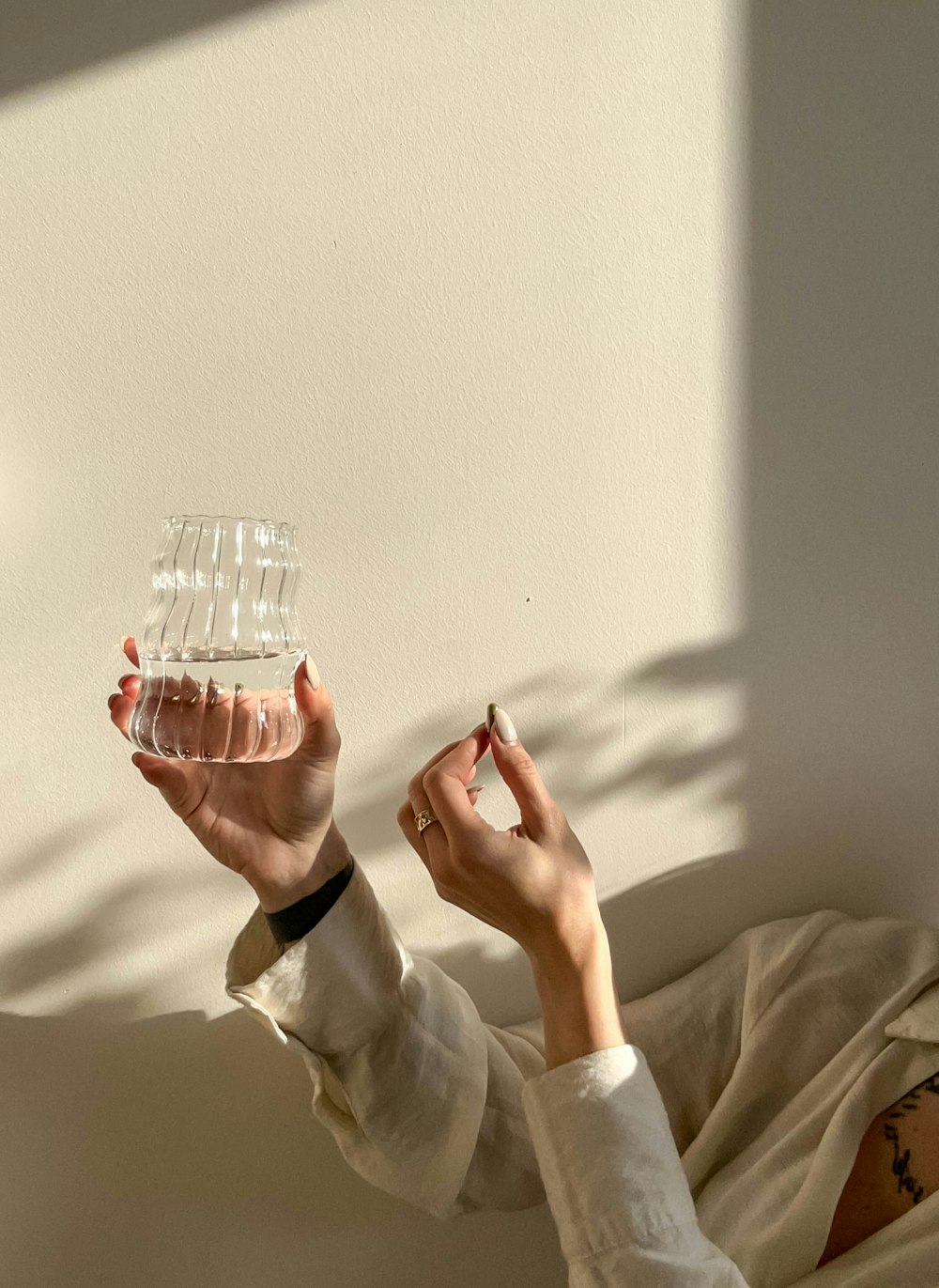 a woman laying on a bed holding a glass of water