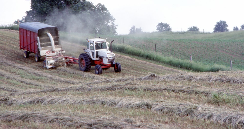 a tractor pulling a trailer behind it in a field