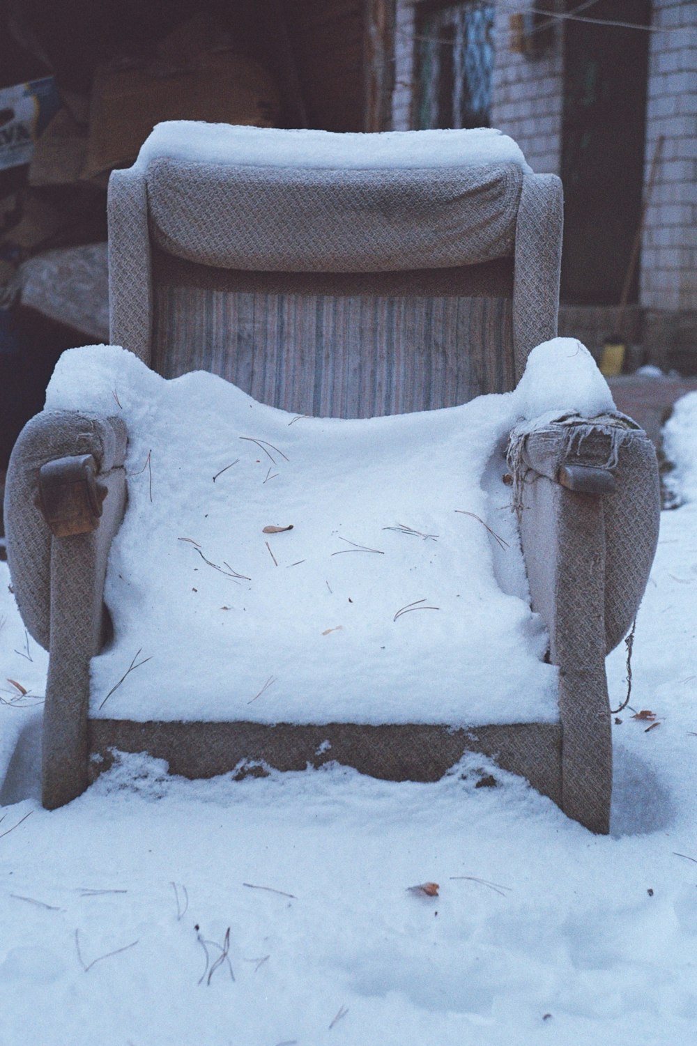 une chaise recouverte de neige devant un bâtiment