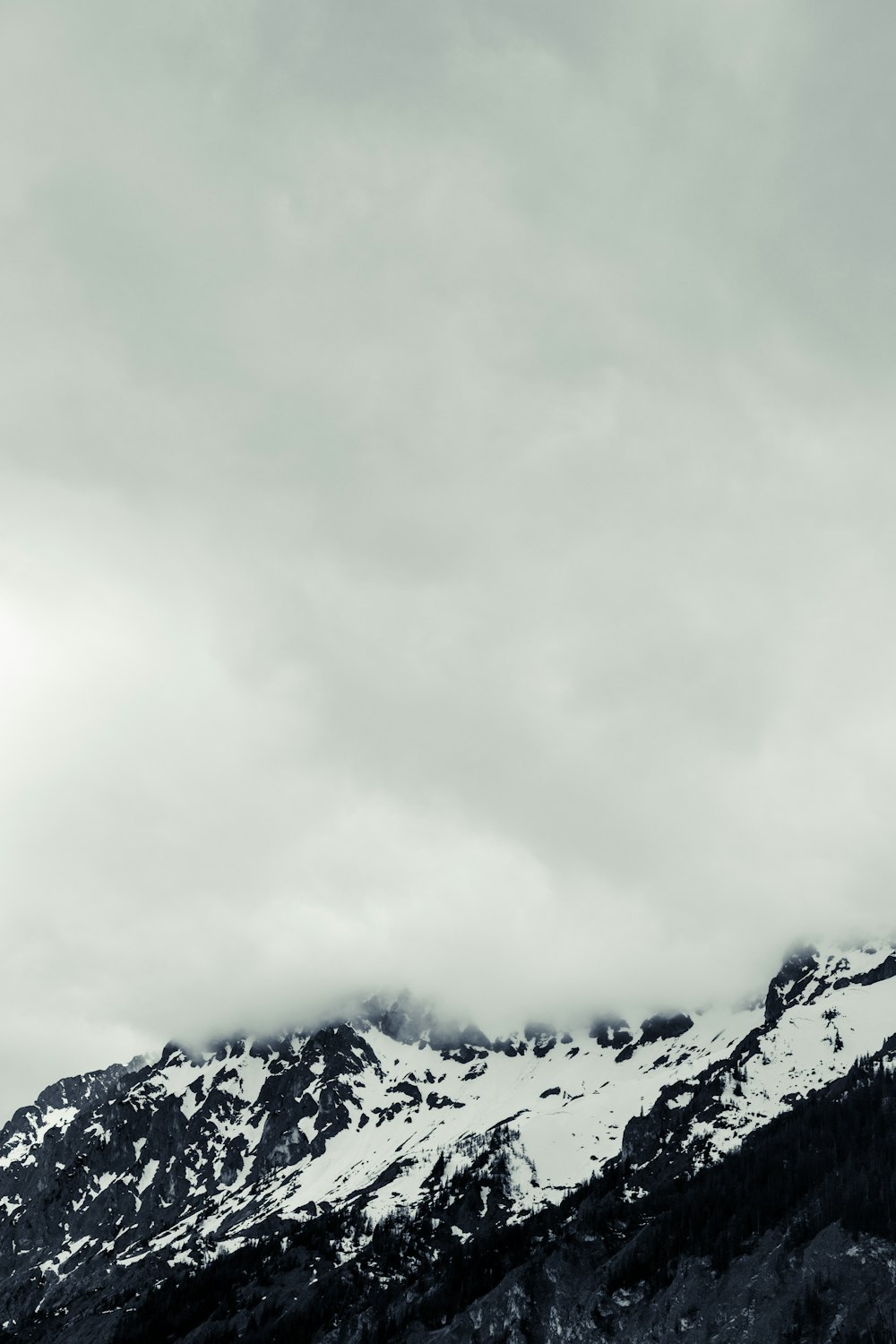 a black and white photo of snow covered mountains