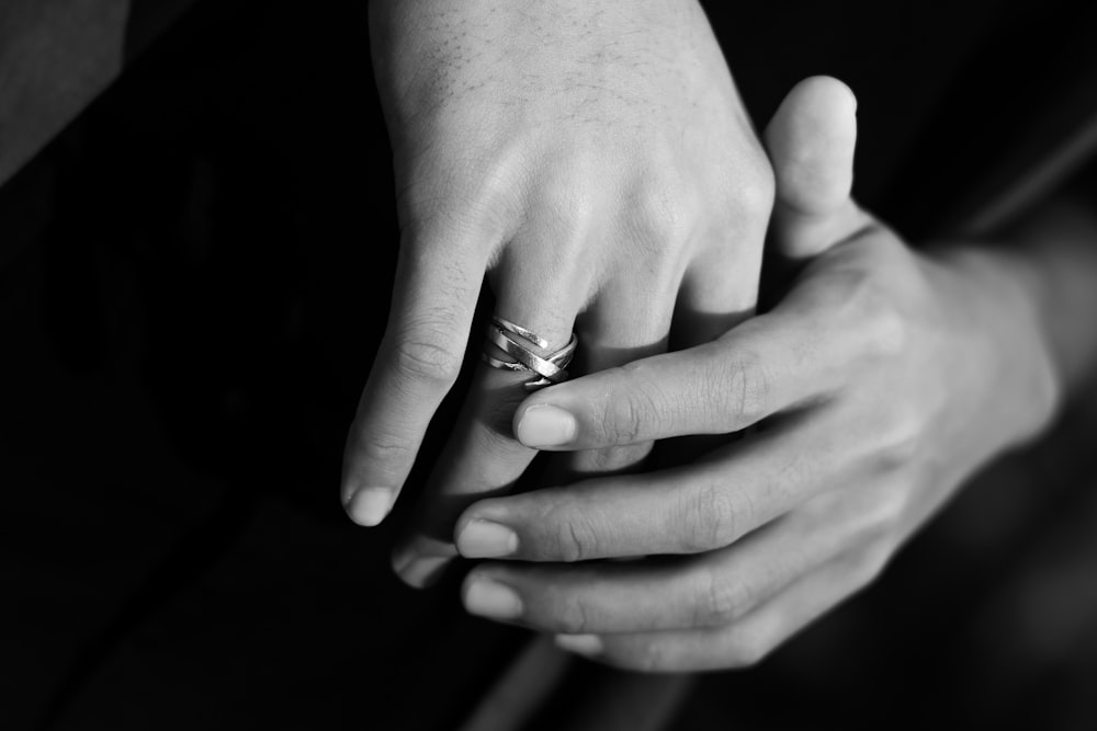 a close up of a person holding a wedding ring