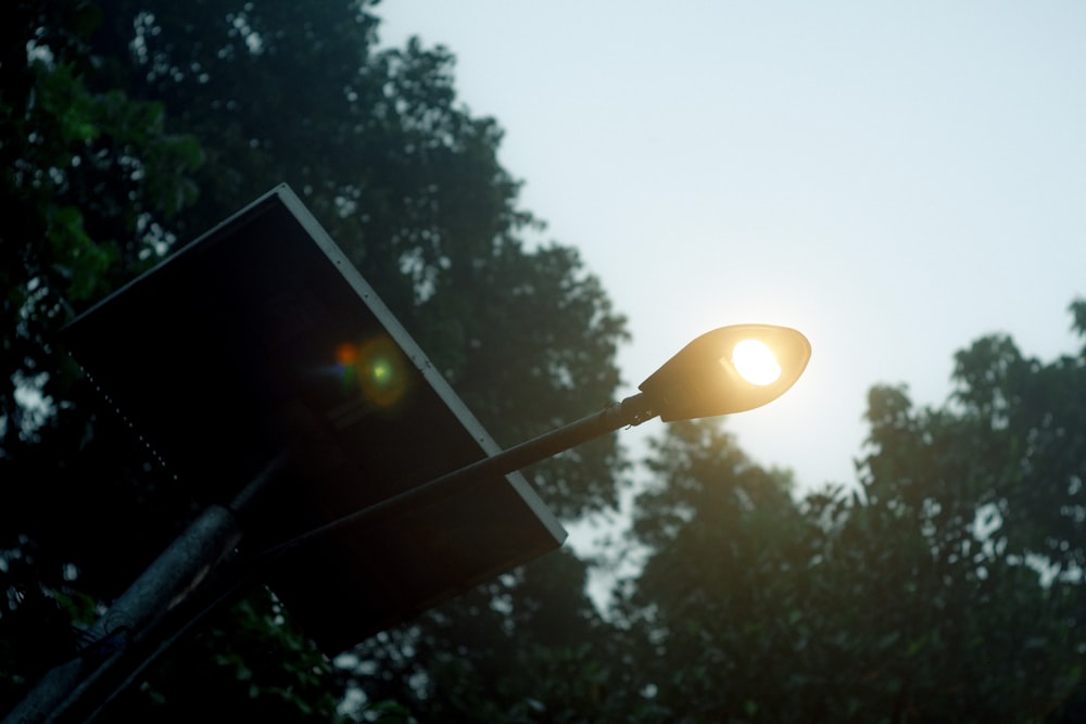 a close up of a street light with trees in the background