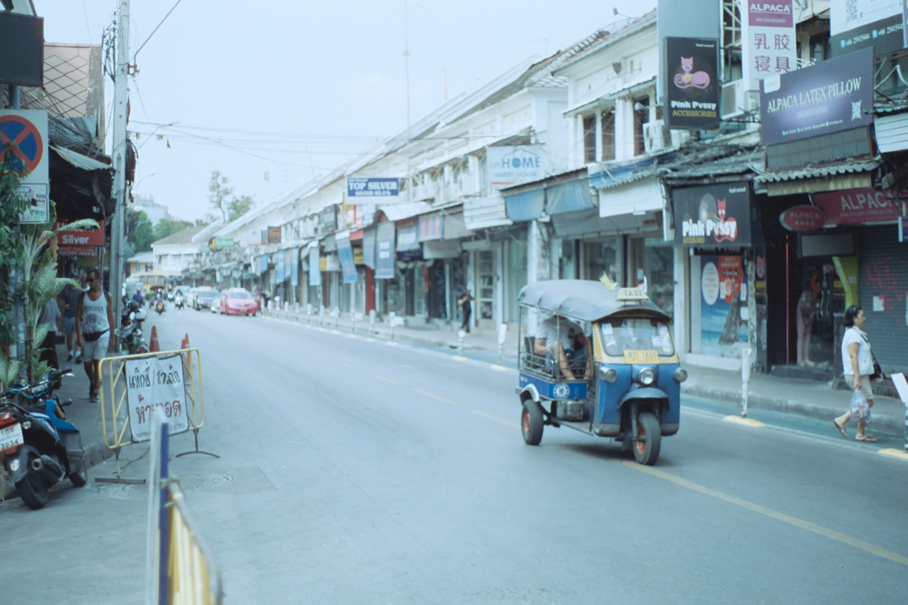 a tuk tuk driving down a city street