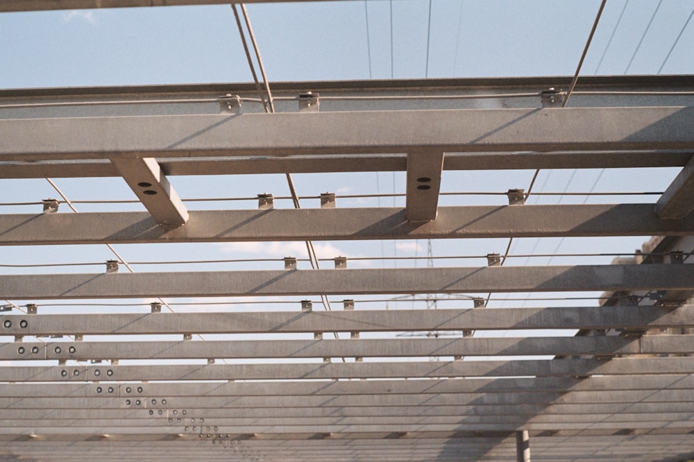 the underside of a metal structure with a sky background